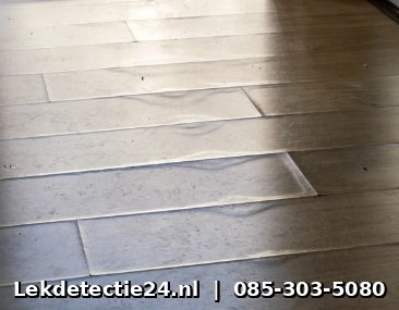 Opbollend parket door verborgen vloerverwarmingslek