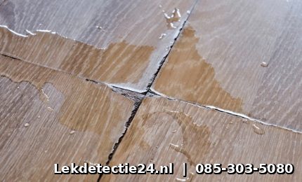 Waterplassen op beschadigde vloer door acute lekkage